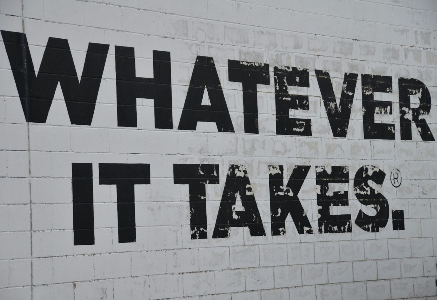 A white brick wall with black words on it